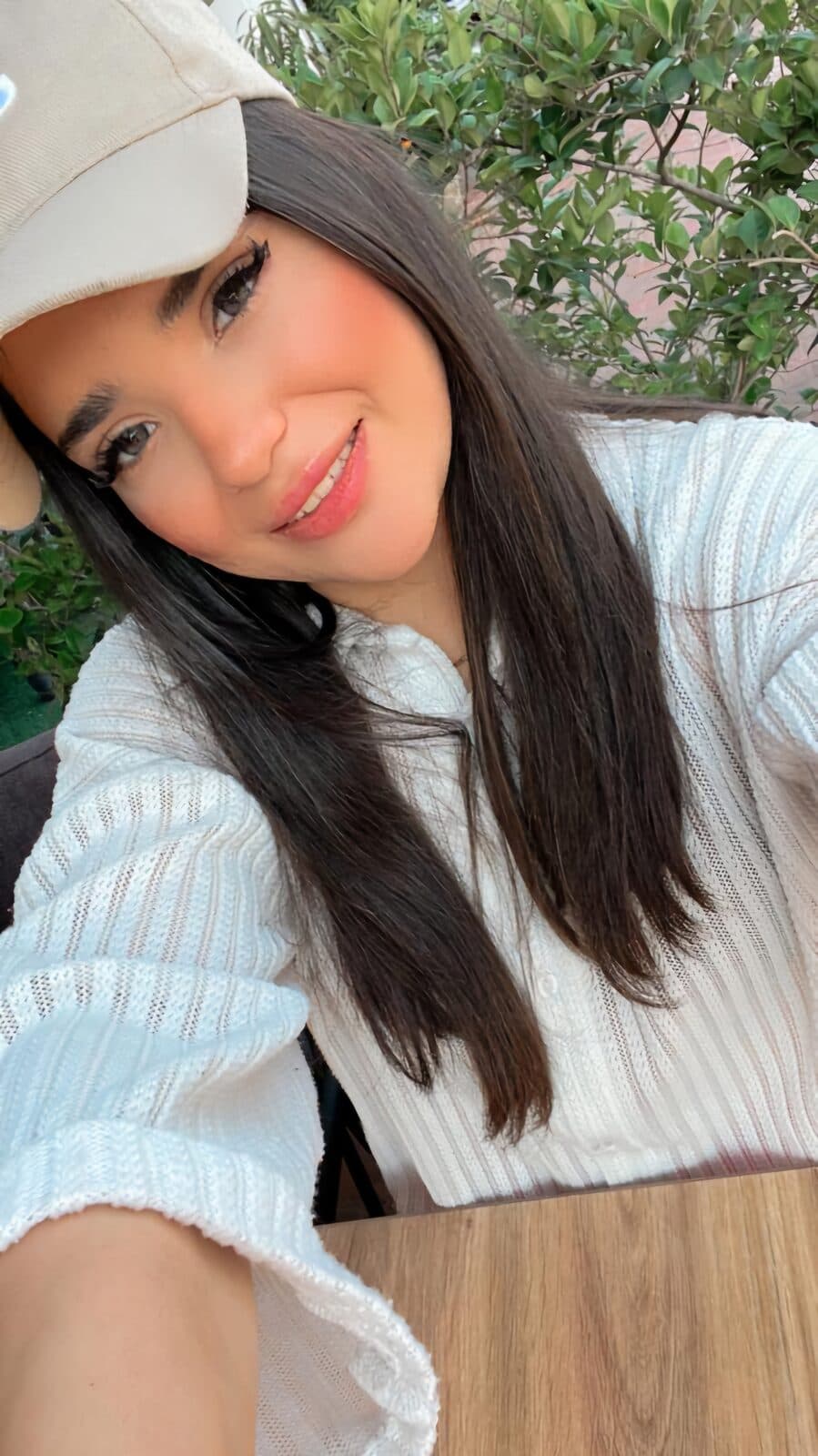 Close portrait of Zahra in a cream cap and white knit